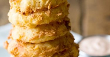 A plate of golden-brown and crispy double-dipped onion rings, ready to be enjoyed as a snack or side dish.