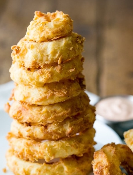 A plate of golden-brown and crispy double-dipped onion rings, ready to be enjoyed as a snack or side dish.