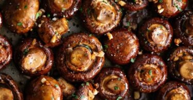 Roasted mushrooms with garlic and thyme on a baking sheet, ready to be served as a delicious and healthy side dish.