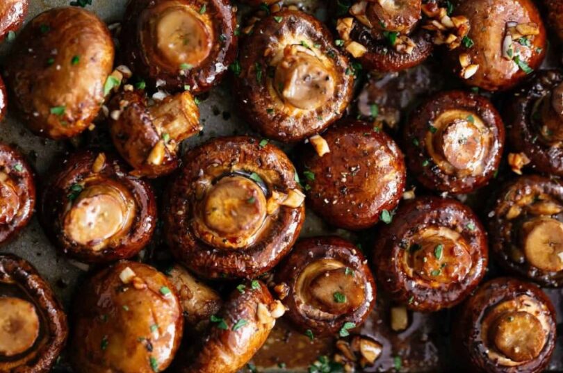 Roasted mushrooms with garlic and thyme on a baking sheet, ready to be served as a delicious and healthy side dish.