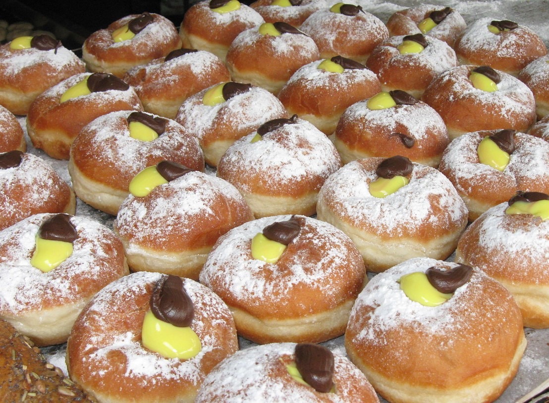 A plate of delicious and fluffy mini brioche donuts filled with sweet pastry cream.