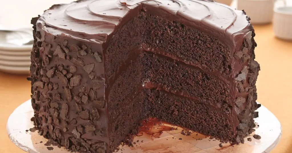A slice of rich and chocolaty chocolate cake with a creamy chocolate buttercream frosting.