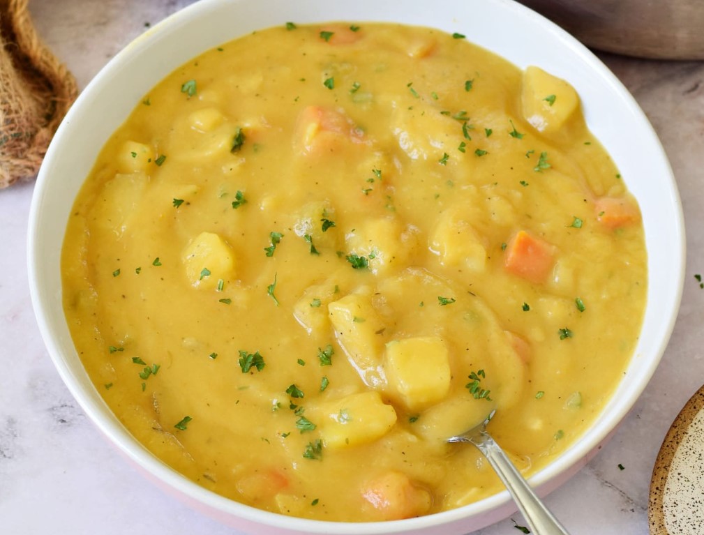 This German potato soup, also known as Kartoffelsuppe, is a staple in German cuisine and a perfect dish for cold winter days. The recipe calls for the zest of one whole lemon, which adds depth to the flavor, as well as green onions for a bit of kick. Vegetable stock is used to make it a fully vegetarian dish, but chicken stock can also be used. It is recommended to use floury potatoes for this recipe, but waxy potatoes can also be used. This soup can be easily made vegan or vegetarian by omitting the sausages or using plant-based sausages. It is gluten-free and can be stored for 3-4 days in the refrigerator or for up to 3 months in the freezer. To serve, it is recommended to have bread on the side. The recipe includes ingredients such as olive oil, onion, garlic, carrot, celery, potatoes, vegetable stock, bay leaf, heavy cream, butter, lemon zest, green onions, salt, pepper, cumin, and nutmeg.