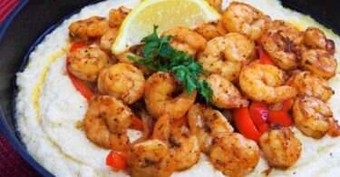 A close-up image of a plate of Cajun Shrimp Scampi, with large succulent shrimp and a spicy Cajun sauce. Cajun Shrimp Scampi is a delicious and spicy dish made with large shrimp, garlic, onions, and bell peppers. Perfect for a quick and easy weeknight meal or special occasion.