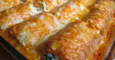 Close-up of homemade lasagna rolls filled with meat and cheese, baked with marinara sauce and topped with melted mozzarella cheese.