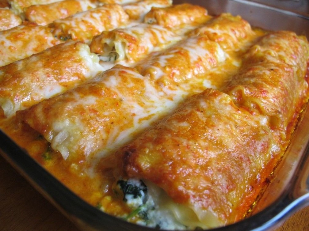 Close-up of homemade lasagna rolls filled with meat and cheese, baked with marinara sauce and topped with melted mozzarella cheese.