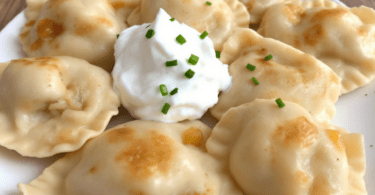 Homemade pierogi served with sour cream and chives