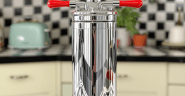 An elegant vintage soda siphon with a chrome body and bright red handles, reminiscent of mid-20th century design, sitting on a retro kitchen counter.