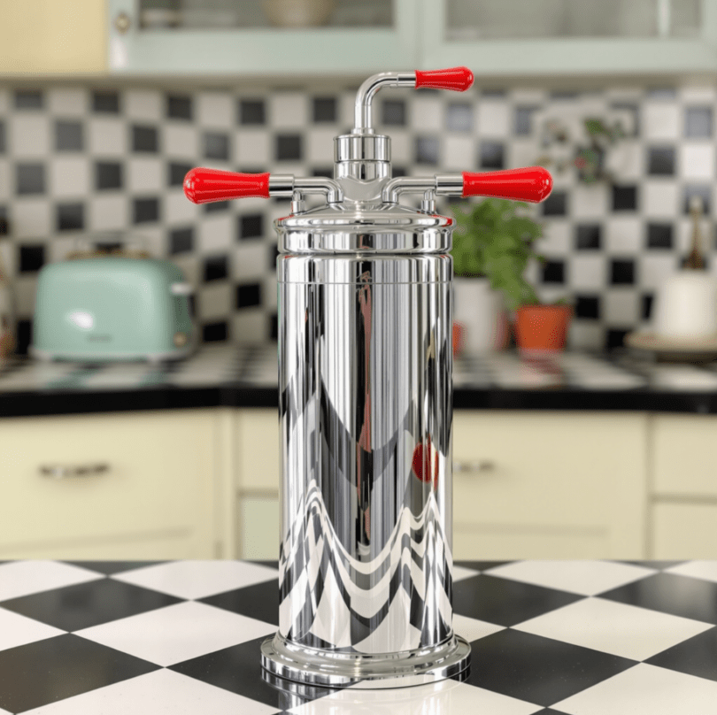 An elegant vintage soda siphon with a chrome body and bright red handles, reminiscent of mid-20th century design, sitting on a retro kitchen counter.