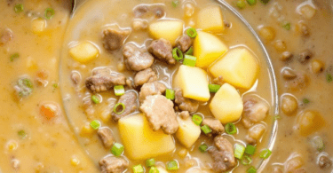 Beef and Potato Soup in a crockpot with a soup ladle full of diced potato and ground beef