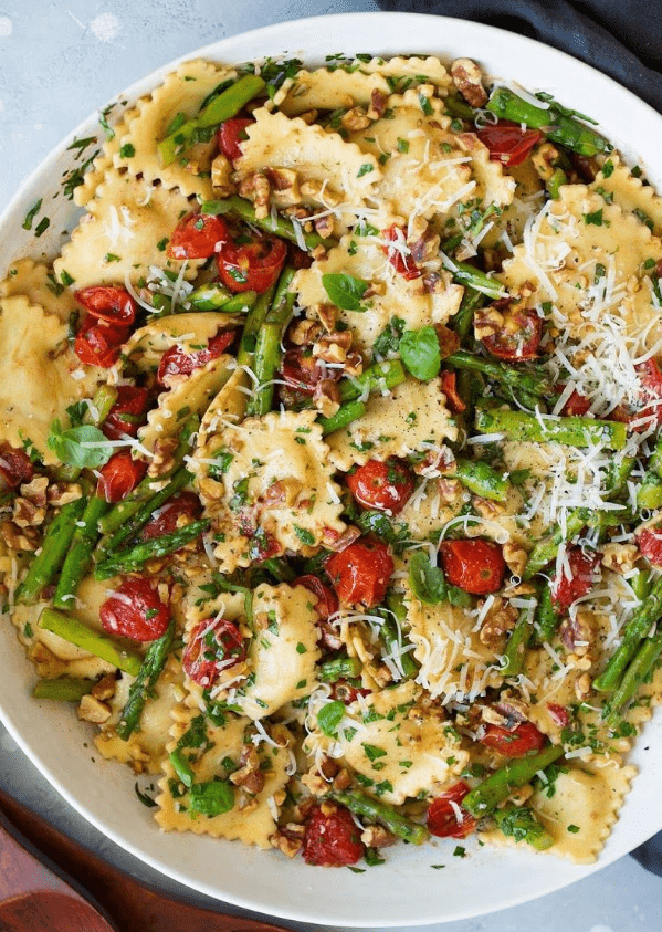 Ravioli with Asparagus & Tomato served in a bowl